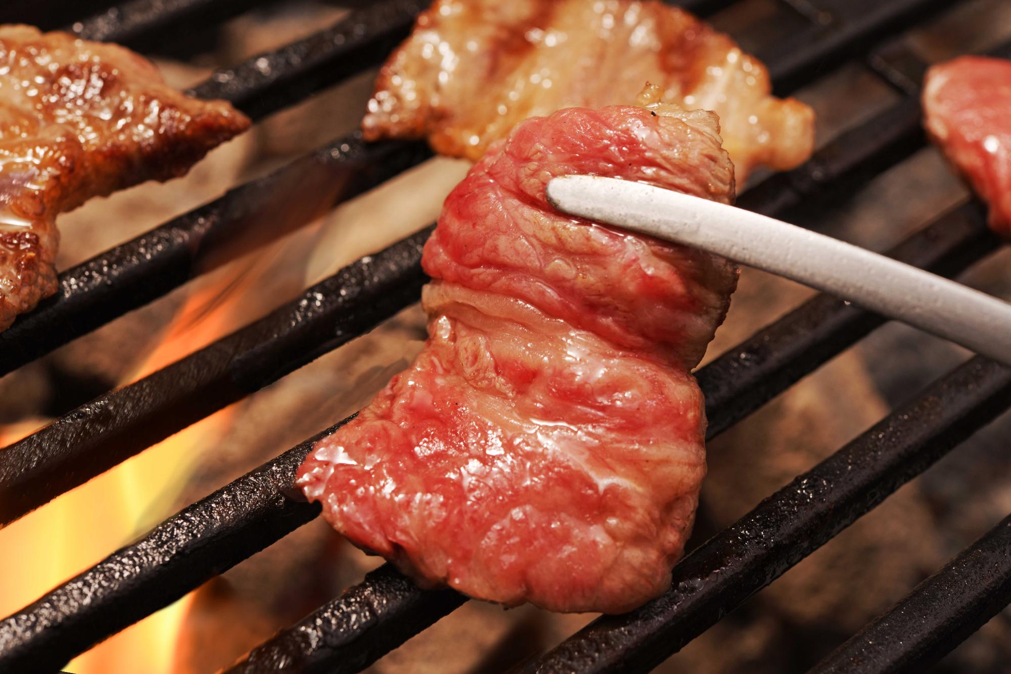 あか牛の肉をプレートの上で焼いている写真