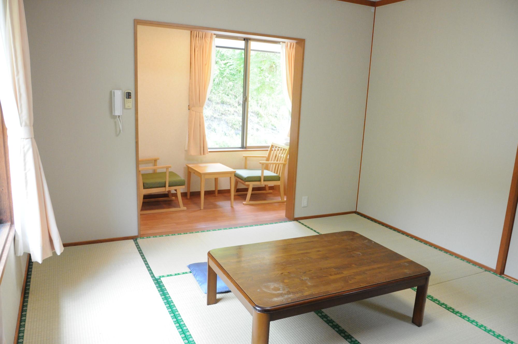 宿泊施設「やすらぎ」の畳部屋と大きな窓がある広縁の写真