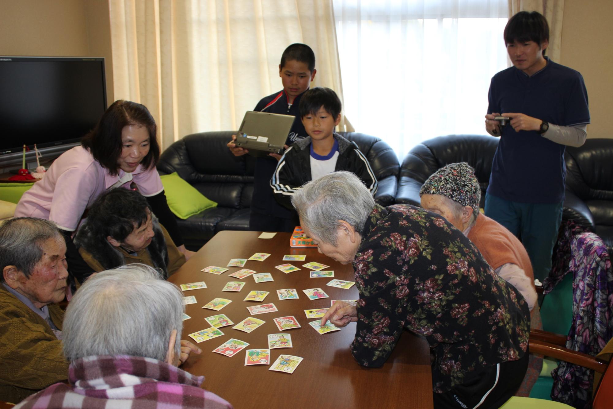 高齢者施設の入居者とゲームをする子供たち