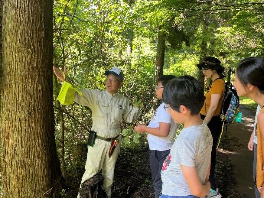 子どもたちに森林インストラクターが説明する様子